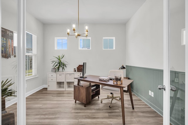 home office with visible vents, an inviting chandelier, a healthy amount of sunlight, and light wood finished floors