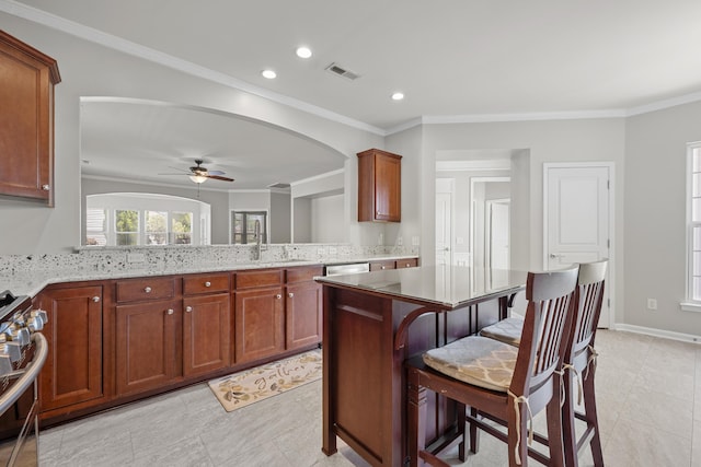 554 Tranquil Waters Way, Summerville, SC 29486 - kitchen with stainless steel range with gas stovetop, arched walkways, visible vents, a ceiling fan, and crown molding