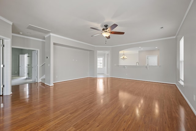 554 Tranquil Waters Way, Summerville, SC 29486 - unfurnished living room with baseboards, visible vents, ceiling fan with notable chandelier, wood finished floors, and crown molding