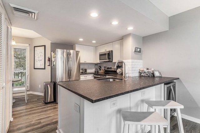 9000 Palmetto Dr Unit 202-C, Isle Of Palms, SC 29451 - kitchen with visible vents, dark wood-style flooring, a sink, stainless steel appliances, and baseboards