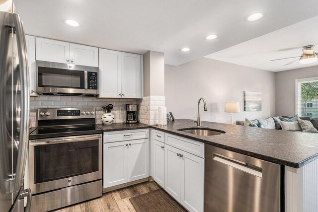 9000 Palmetto Dr Unit 202-C, Isle Of Palms, SC 29451 - kitchen featuring a sink, appliances with stainless steel finishes, a peninsula, light wood finished floors, and backsplash