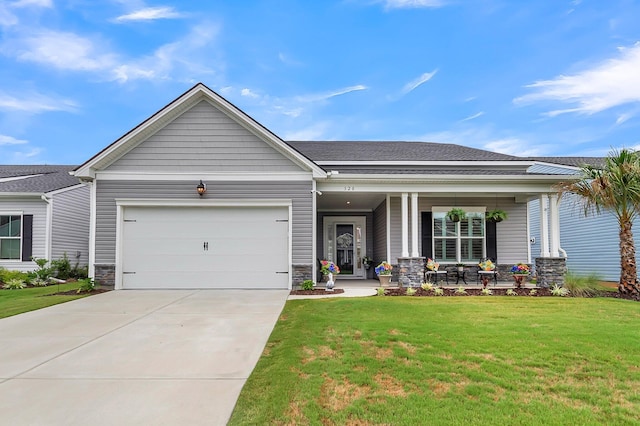 view of front of house with covered porch, a front yard, and a garage