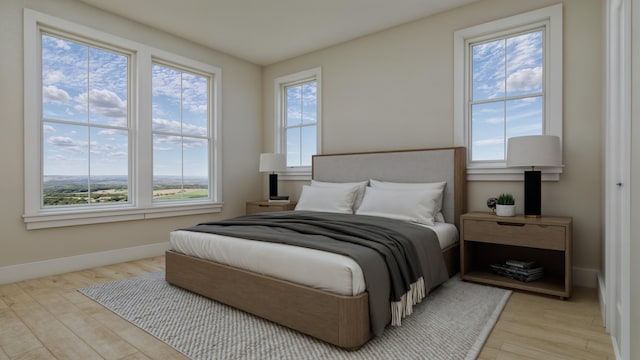 bedroom featuring light hardwood / wood-style flooring and multiple windows