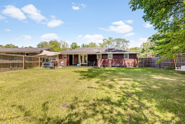 1821 Wasp St, North Charleston, SC 29405 - rear view of property featuring a fenced backyard, a patio area, a yard, and brick siding