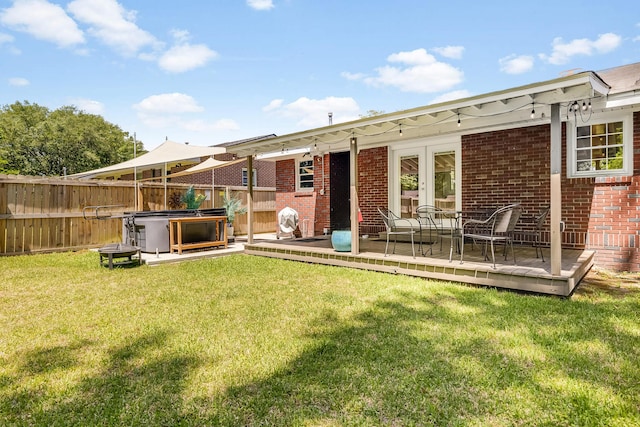 1821 Wasp St, North Charleston, SC 29405 - back of house with fence, a wooden deck, brick siding, and a lawn
