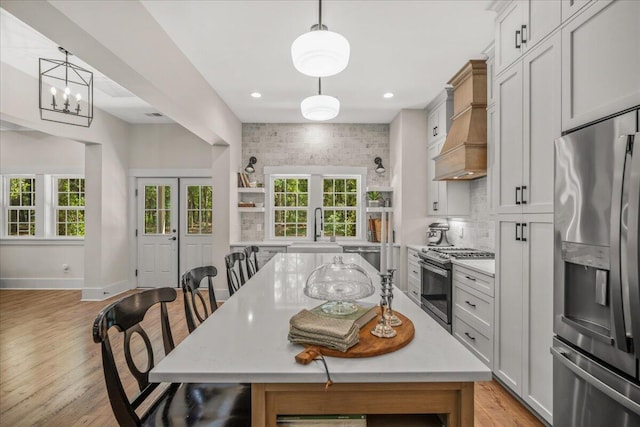 kitchen featuring stainless steel appliances, a sink, light wood finished floors, plenty of natural light, and recessed lighting