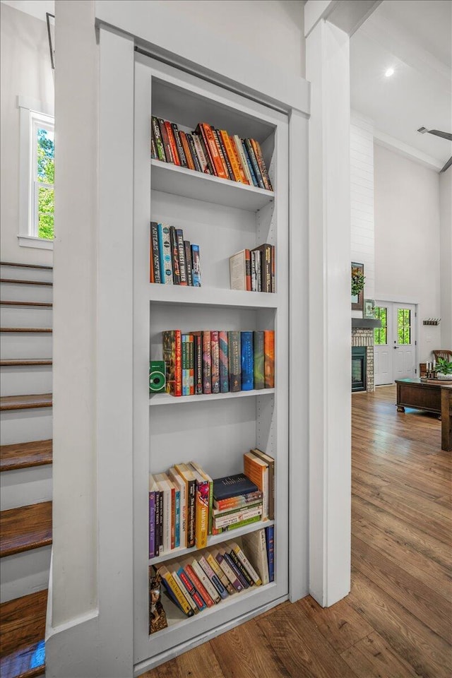 detailed view of wood finished floors, a fireplace, and recessed lighting