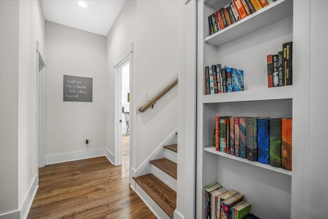 foyer featuring wood finished floors, baseboards, stairway, and recessed lighting