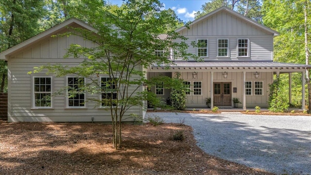 view of front of property featuring board and batten siding, a porch, french doors, and metal roof