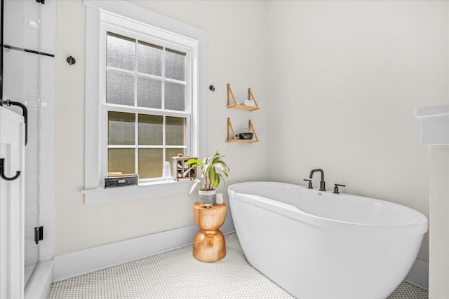 full bathroom with healthy amount of natural light, a shower stall, and baseboards
