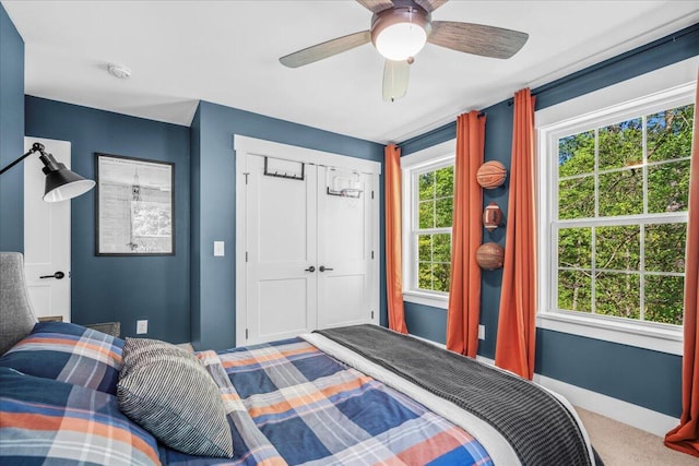 bedroom with carpet, baseboards, a ceiling fan, and a closet