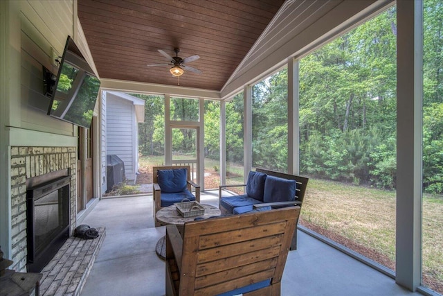 sunroom / solarium featuring an outdoor living space with a fireplace and a ceiling fan