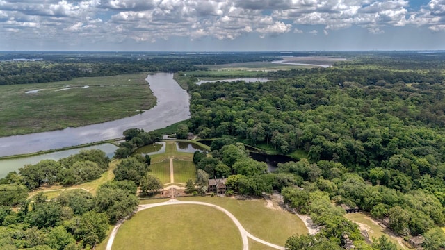 drone / aerial view of a large body of water and a heavily wooded area