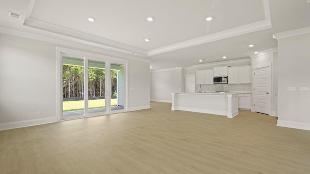 205 Bilge Rd, Ridgeville, SC 29472 - unfurnished living room with ornamental molding, a tray ceiling, light wood finished floors, and recessed lighting