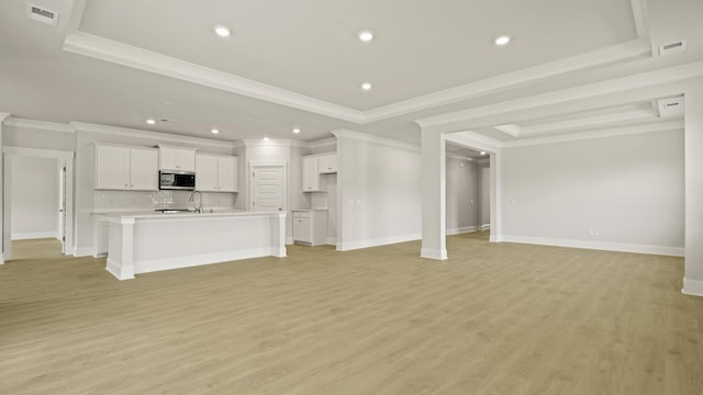 205 Bilge Rd, Ridgeville, SC 29472 - unfurnished living room with a tray ceiling, light wood-style floors, ornamental molding, and recessed lighting