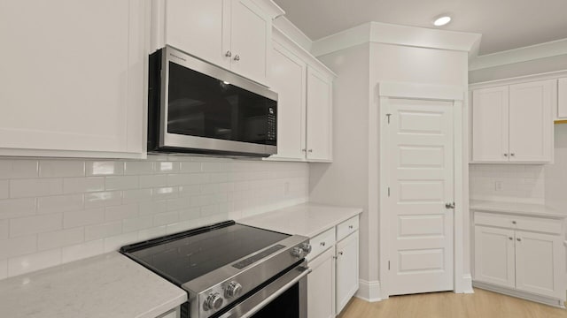 205 Bilge Rd, Ridgeville, SC 29472 - kitchen featuring stainless steel appliances, white cabinetry, tasteful backsplash, light wood-style flooring, and light stone countertops