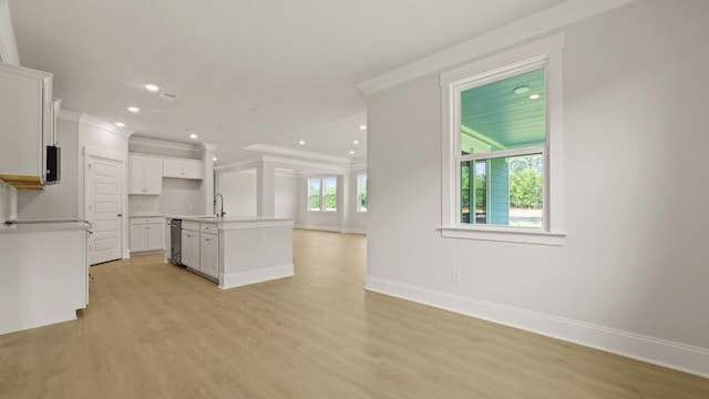 205 Bilge Rd, Ridgeville, SC 29472 - kitchen featuring open floor plan, crown molding, light wood-type flooring, a center island with sink, and white cabinetry