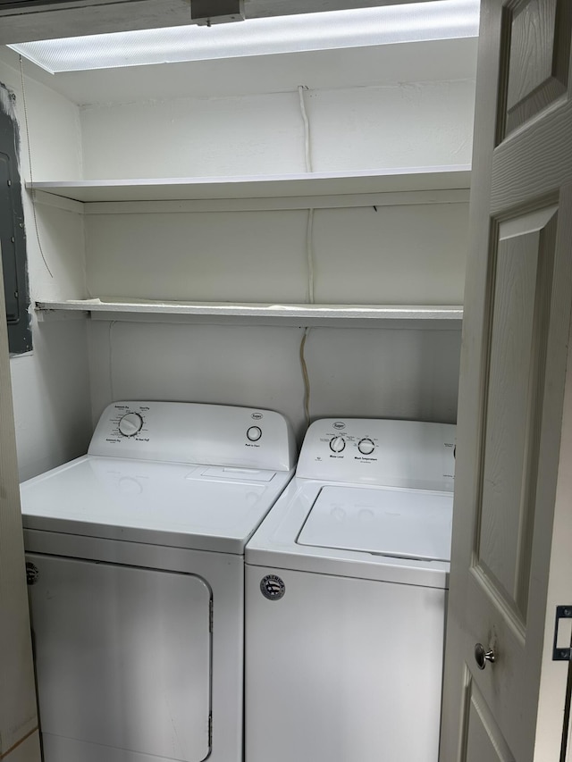 clothes washing area featuring electric panel and independent washer and dryer