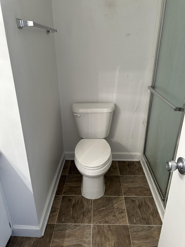 bathroom with toilet and a shower with shower door