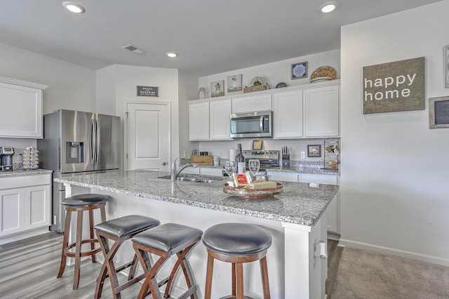 kitchen featuring a sink, white cabinets, visible vents, and stainless steel appliances