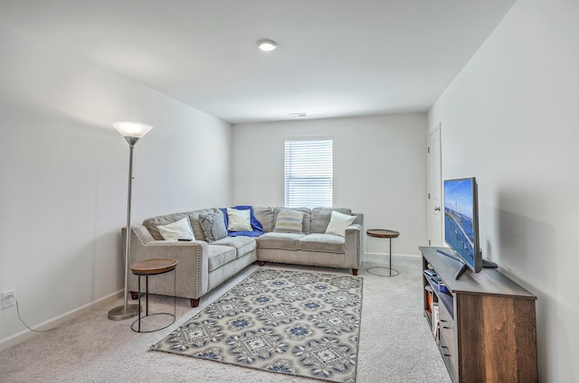 carpeted living area with baseboards