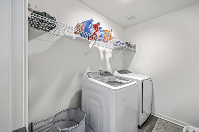 laundry area featuring dark wood-style floors, baseboards, visible vents, laundry area, and washing machine and dryer