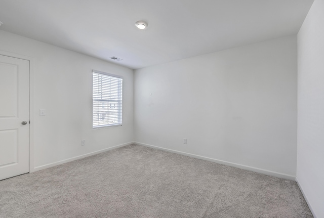 unfurnished room with visible vents, baseboards, and carpet