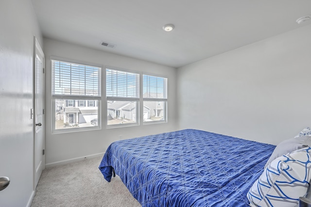 carpeted bedroom featuring baseboards and visible vents