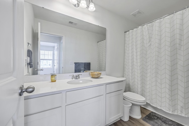 full bathroom featuring vanity, toilet, wood finished floors, and visible vents