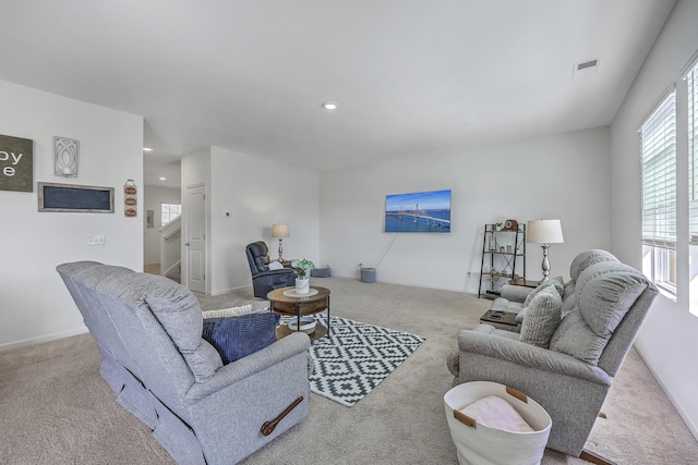 living area featuring visible vents, baseboards, stairway, carpet floors, and recessed lighting