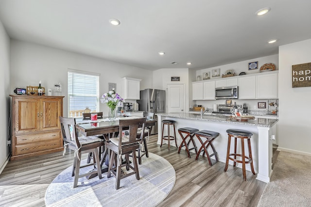 dining space with recessed lighting, baseboards, and light wood-style floors