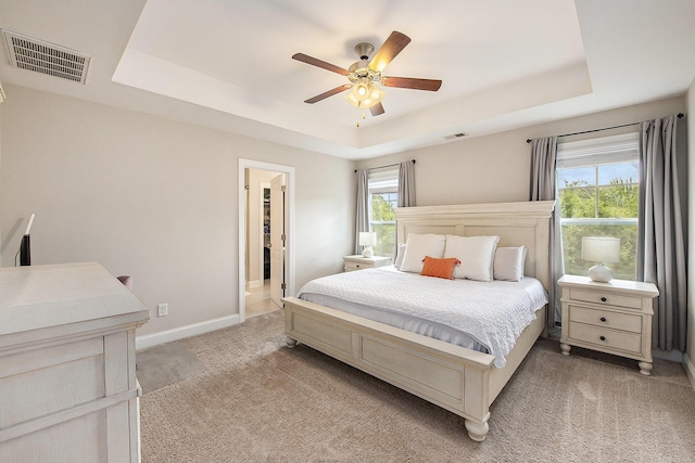 4117 Rigsby Ln, Charleston, SC 29414 - bedroom featuring a tray ceiling, light carpet, multiple windows, and a ceiling fan
