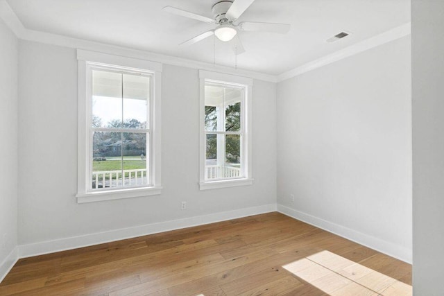 spare room with visible vents, crown molding, baseboards, and hardwood / wood-style floors