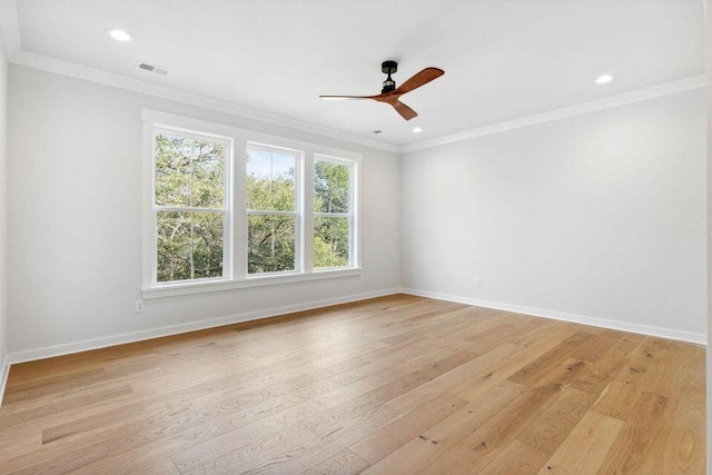 empty room featuring crown molding, baseboards, visible vents, and light wood-style floors