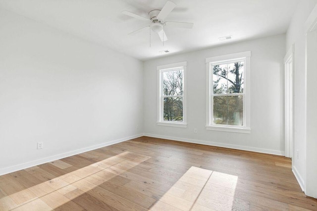 spare room featuring visible vents, ceiling fan, baseboards, and wood finished floors