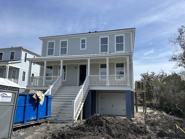 beach home featuring covered porch, stairway, and a garage