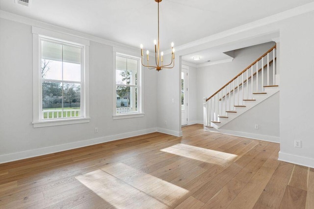 interior space featuring ornamental molding, wood-type flooring, baseboards, and stairs