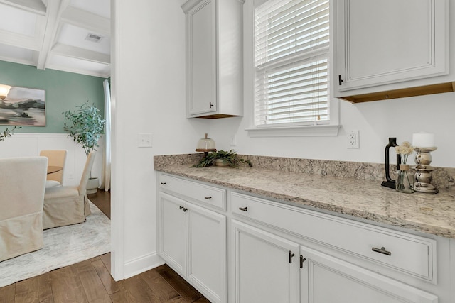 kitchen with coffered ceiling, white cabinets, beamed ceiling, dark hardwood / wood-style flooring, and light stone counters