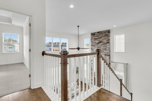 stairway featuring hardwood / wood-style flooring, plenty of natural light, and ceiling fan