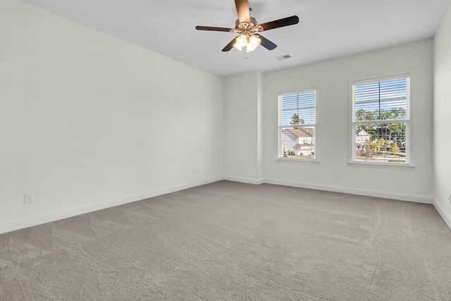 carpeted spare room featuring ceiling fan