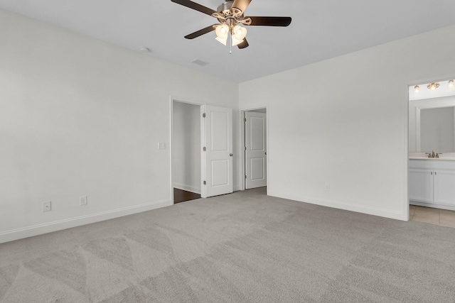 unfurnished bedroom with connected bathroom, ceiling fan, sink, and light colored carpet