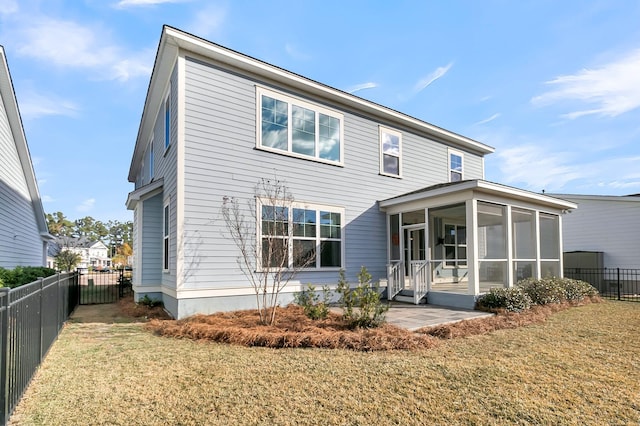 back of property featuring a sunroom, a patio area, and a yard