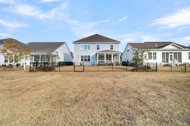 back of property with a yard and a sunroom