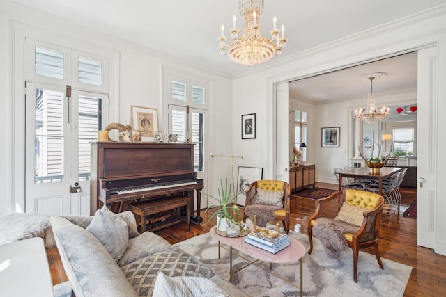 living room with ornamental molding, hardwood / wood-style floors, and an inviting chandelier