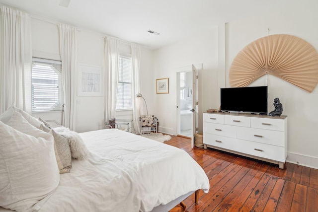 bedroom featuring connected bathroom and hardwood / wood-style floors