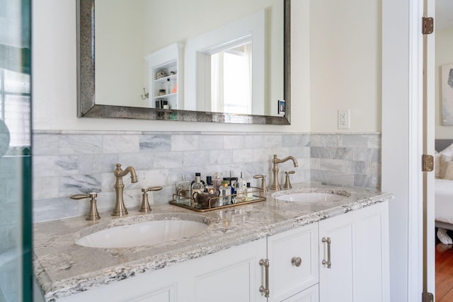 bathroom with hardwood / wood-style floors, dual vanity, and decorative backsplash