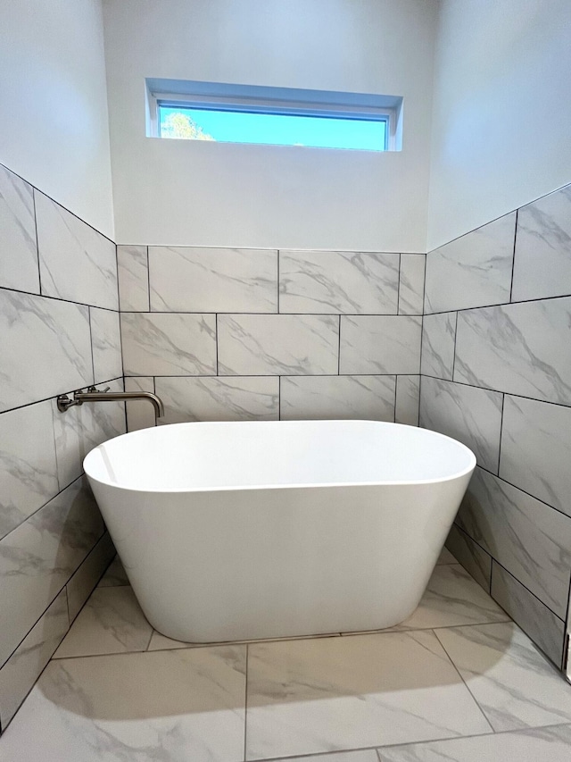 bathroom featuring a bath and a wealth of natural light