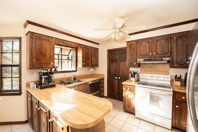 kitchen featuring sink, a healthy amount of sunlight, white range with electric stovetop, a textured ceiling, and light tile patterned floors