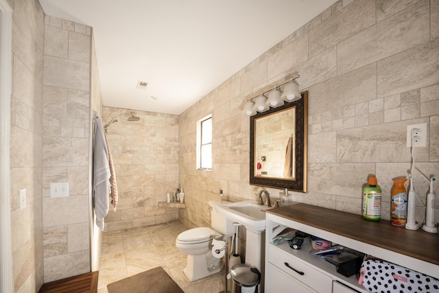 bathroom with a shower, sink, tile walls, and toilet