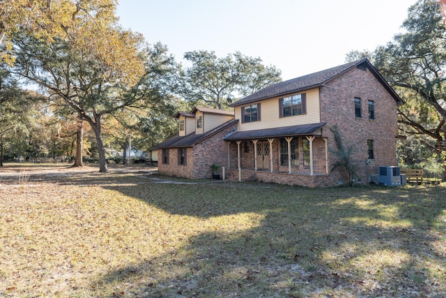 view of front of home with a front yard and central AC